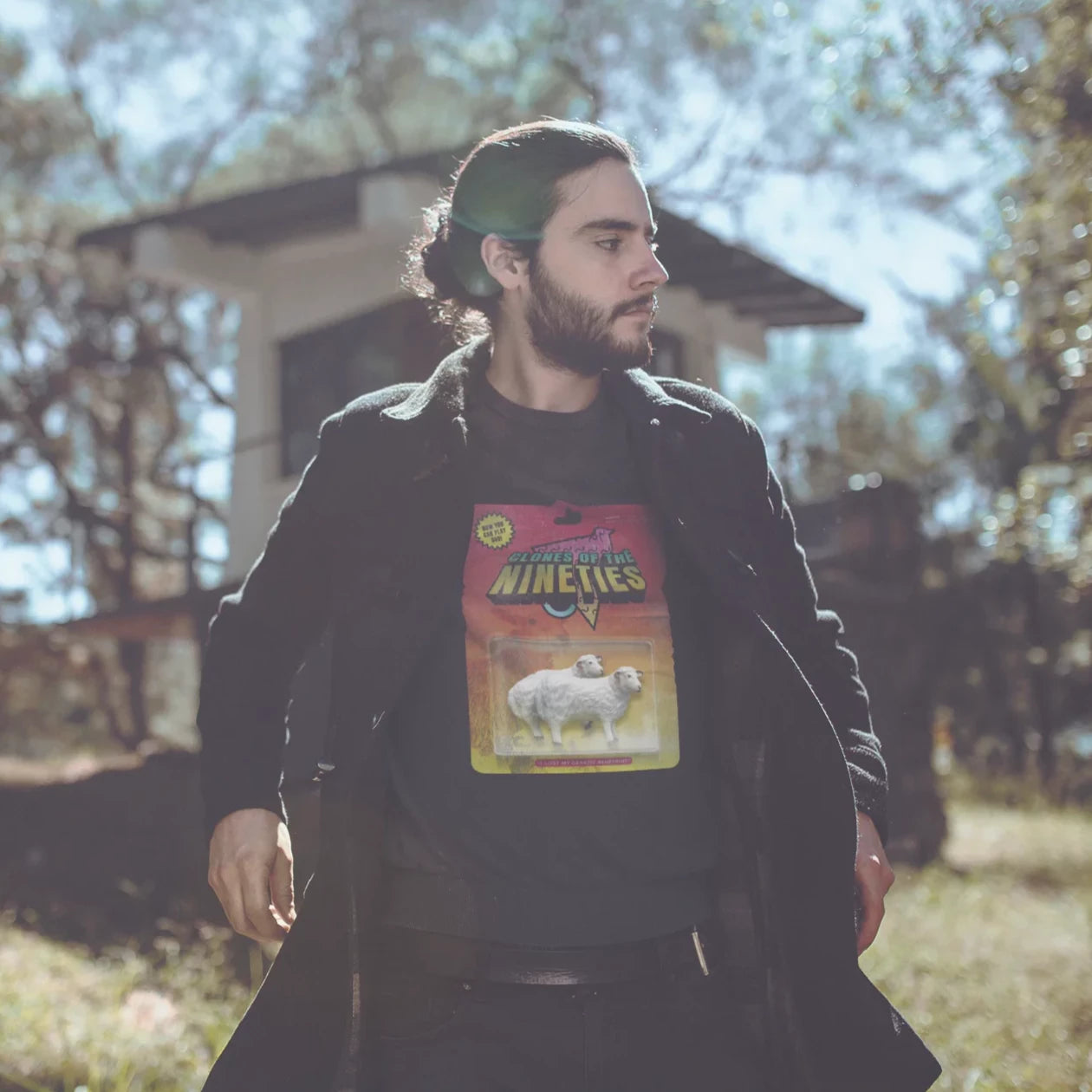 hombre en el bosque usando una sudadera streetwear de color negro con ilustracion retro de los noventas dolly clon  