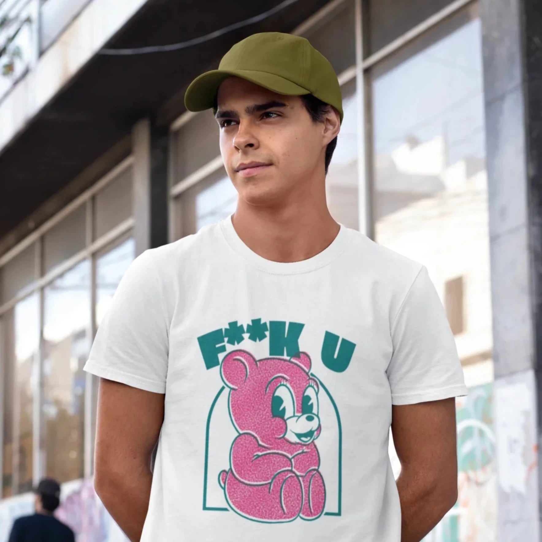 "Hombre en la calle vistiendo una playera de color blanco con diseno streetwear de un oso, tonos rosa y verde."