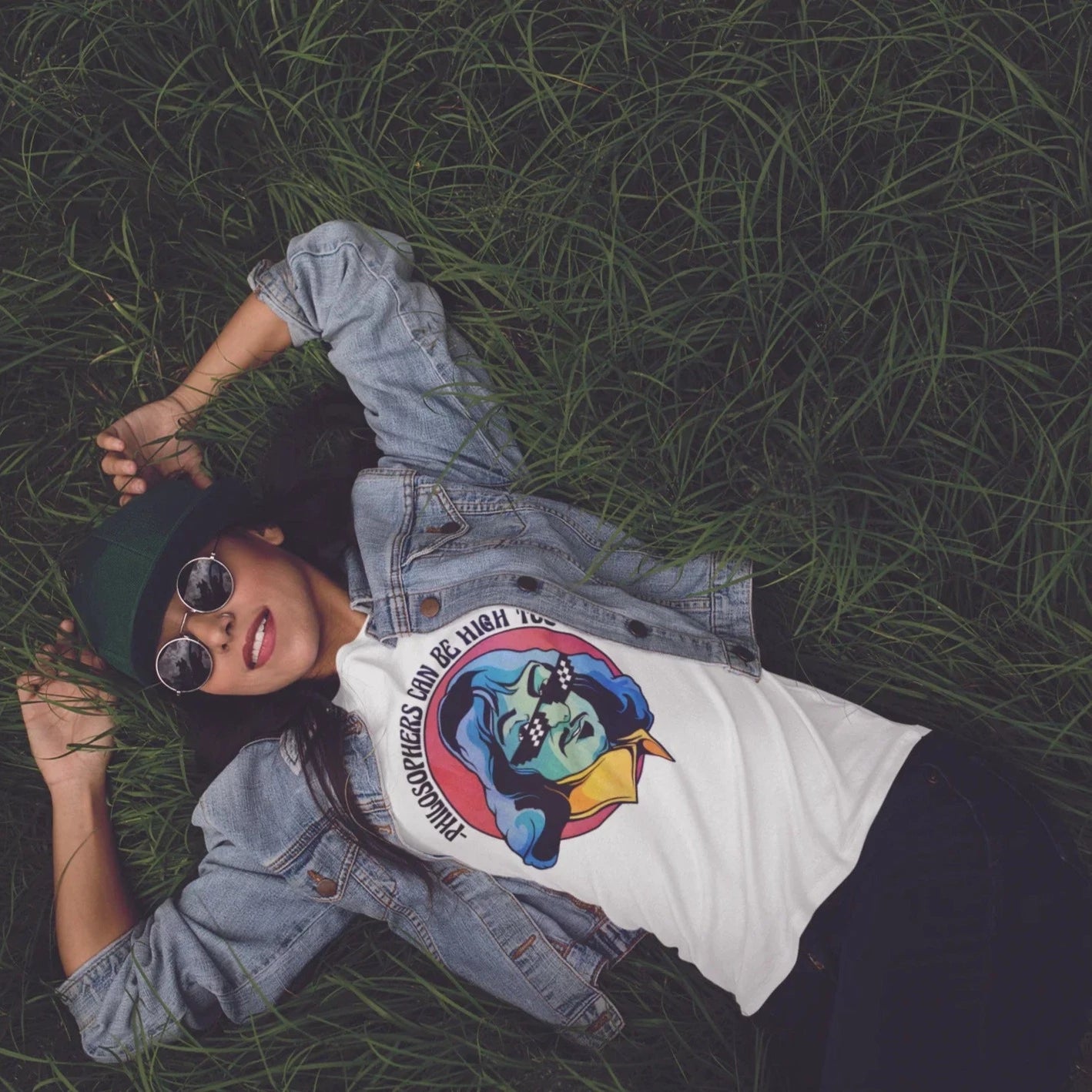 mujer con lentes acostada en el pasto vistiendo playera de color blanco con diseño retro de filosofo con frase graciosa  PSW809008